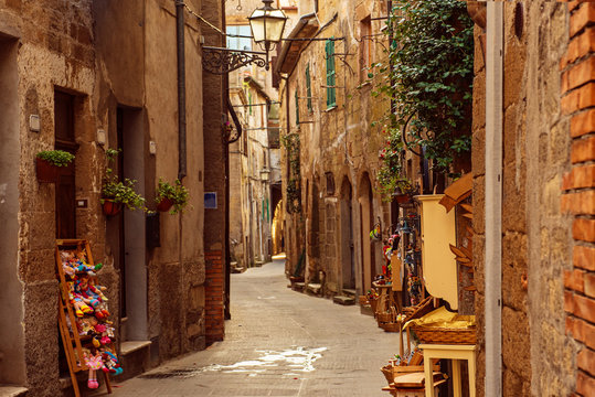 Fototapeta Narrow street of medieval ancient tuff city Pitigliano, travel Italy background