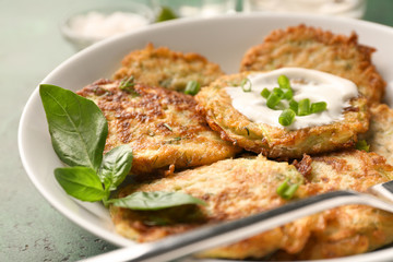 Plate with zucchini pancakes and sauce, closeup