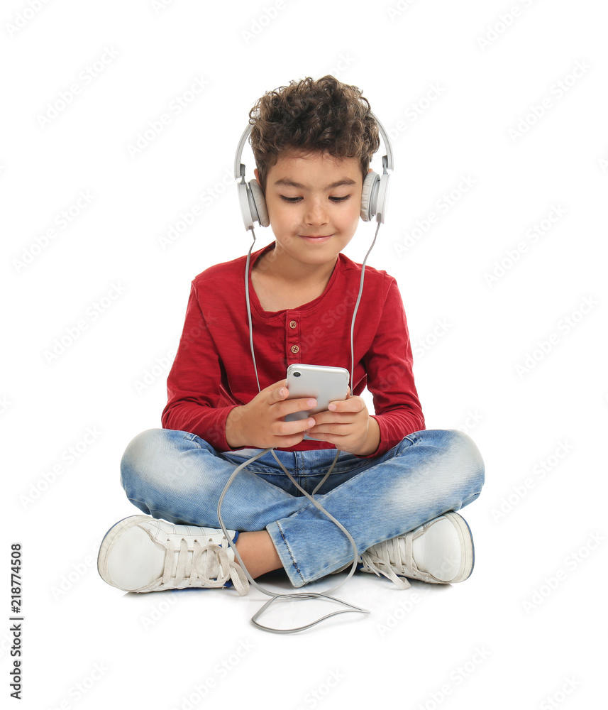 Wall mural cute little boy with headphones listening to music on white background