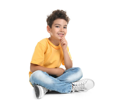 Cute little boy sitting on white background
