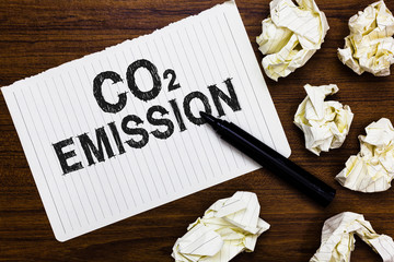 Text sign showing Co2 Emission. Conceptual photo Releasing of greenhouse gases into the atmosphere over time Marker over notebook crumpled papers ripped pages several tries mistakes.