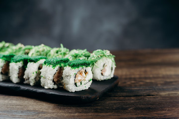 Restaurant menu, Japanese food art. Appetizing sushi rolls set, served on wooden tray. Free space for text design