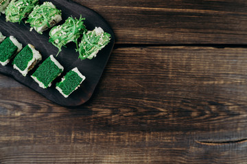 Japanese restaurant, sushi plate. Delicious seafood maki rolls on black wooden tray, copy space