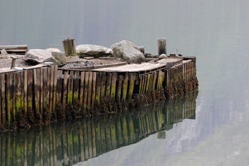 Old wooden pier reflected in water