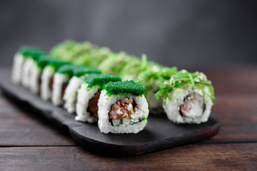 Japanese cuisine, seafood, restaurant menu, food photo art. Delicious sushi rolls set served on wooden tray