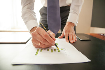 Businessman analyzing investment charts. Hands of financial manager taking notes when working