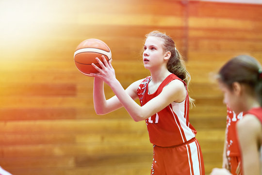 Girl basketball player throws ball in game