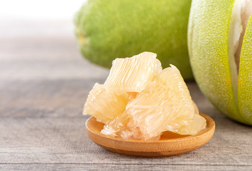 fresh and peeled pomelo(shaddock), grapefruit with slices on wooden table background