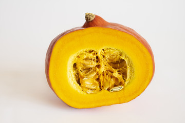 Isolated Half cut orange red kuri hokkaido japanese squash over the white background close up