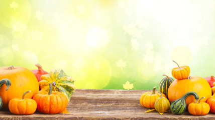 pile of orange pumpkins on wooden table over fall background banner with copy space