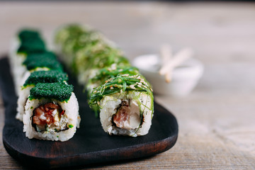 Japanese  food, gourmet eating, restaurant menu. Delicious sushi rolls on wooden tray close up with copy space
