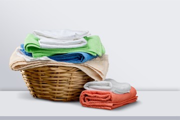 Laundry Basket with colorful towels on background