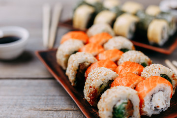 Japanese traditional cuisine. Food photo art, professional culinary, seafood restaurant menu. Appetizing tasty sushi rolls set served on clay trays, selective focus