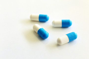Capsules, white and blue. White background.