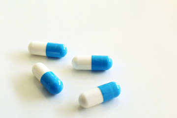 Capsules, white and blue. White background.