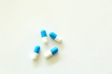 Capsules, white and blue. White background.