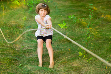Sporty girl in tug of war competition in summer vacations