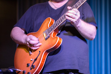 Mid section of man playing guitar