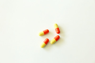 Yellow-red capsules. Some capsules and pills isolated on white background