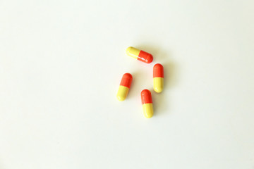 Yellow-red capsules. Some capsules and pills isolated on white background