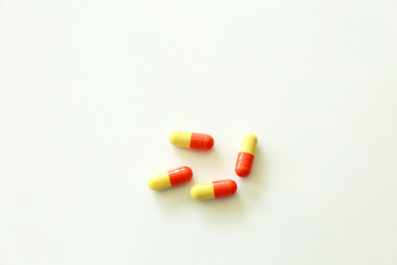 Yellow-red capsules. Some capsules and pills isolated on white background