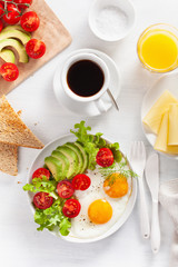 healthy breakfast flat lay. fried eggs, avocado, tomato, toasts and coffee