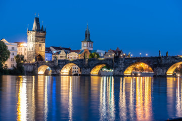 Fototapeta na wymiar Illuminated Charles Bridge reflected in Vltava River. Evening in Prague, Czech Republic.