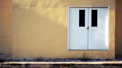 White door on the yellow wall. background.