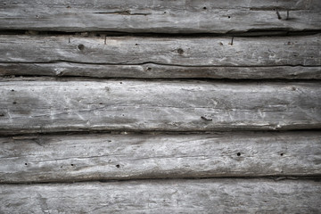 Obraz premium Rough old weathered log cabin background wall closeup