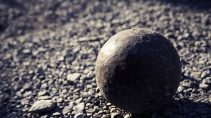 Old petanque balls on the ground. Steel ball on the ground. Light and shadow.