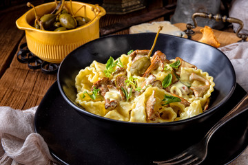 Reginette noodles in cream sauce with fresh chanterelles and capers