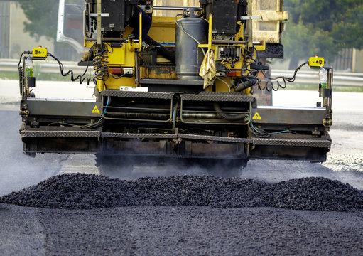 Asphalt paver with asphalt heated to temperatures above 160 ° during road at the construction