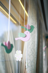decor in the form of wooden birds in pink. Birds have peppermint wings. They are suspended on a satin ribbon