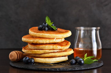 Homemade oat pancakes with honey and blueberries for breakfast on a stone plate. Good morning!