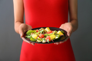 Woman holding plate with healthy fresh salad, closeup