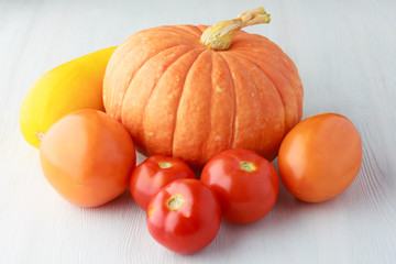 Heirloom raw organic vegetables on a white textured wooden background