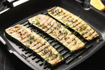 Pan with tasty grilled zucchini on table, closeup