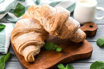 Tasty croissants on wooden board