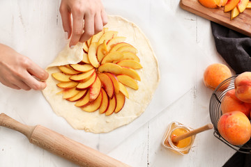 Woman preparing peach galette