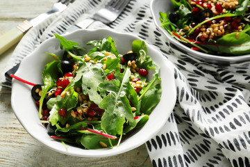 Bowl with healthy fresh salad on wooden table