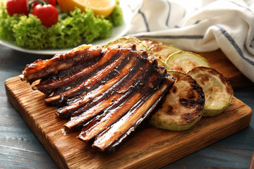 Delicious grilled ribs and zucchini on wooden board