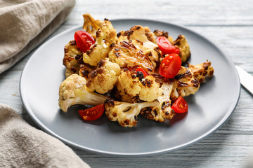 Tasty grilled cauliflower with tomatoes on plate
