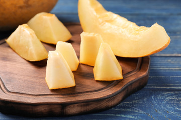 Slice and pieces ripe melon on wooden board