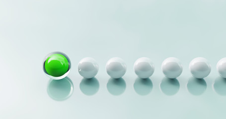 Concept for team spirit. White balls in a row follow a green ball. Symbol for a team leader