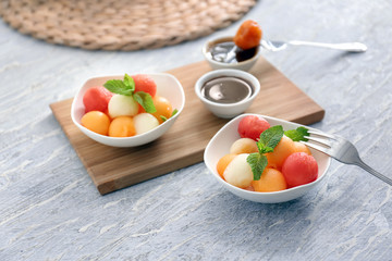 Plates with tasty melon dessert on wooden table