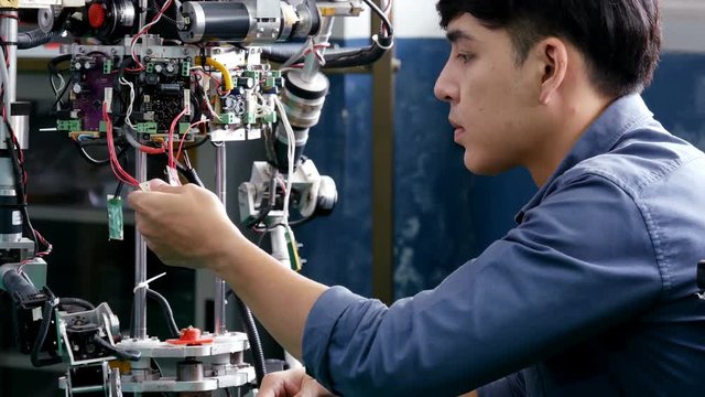 Engineering collaborating on develop of robot in laboratory together. 4K Resolution.