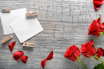 Beautiful red roses and cards on wooden background