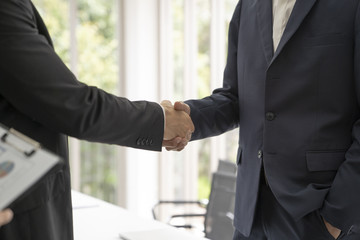 Young business man shaking hands during meeting in office. Success,dealing,greeting ,busisess partner concept.