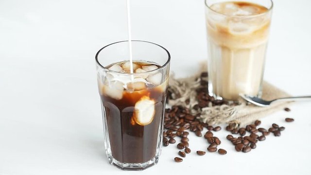 Cream poured into a iced coffee cocktail