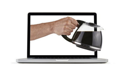 laptop with man's hand holding and pouring coffee
